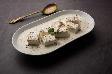 Paneer Dum Kali Mirch / Kalimirch, prepared in a white creamy gravy and black pepper powder sprinkled over it. served in a bowl. Selective focus