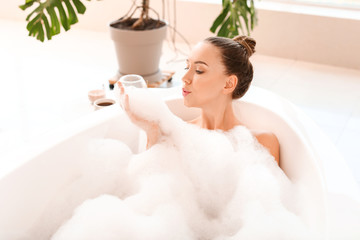 Naklejka premium Beautiful young woman relaxing in bathtub