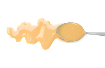 Spoon with tasty tahini on white background