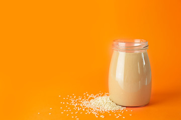 Jar of tasty tahini on white background