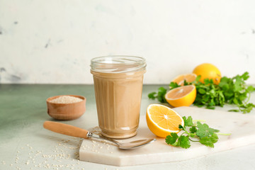 Jar of tasty tahini on light background