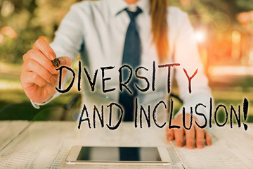 Text sign showing Diversity And Inclusion. Business photo text range huanalysis difference includes race ethnicity gender Female business person sitting by table and holding mobile phone
