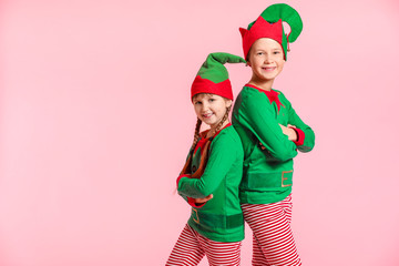 Little children in costume of elf on color background
