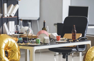 Table with terrible mess in office after New Year party