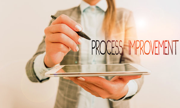 Word writing text Process Improvement. Business photo showcasing ongoing effort to improve products services or processes Business woman pointing in empty space with pen and mobile phone