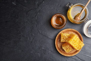Flat lay composition with delicious honey on black table. Space for text