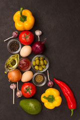 A set of vegetables for a healthy diet, yellow and red peppers, tomatoes, onions, garlic, eggs, olives, rocket,  spinach.  .