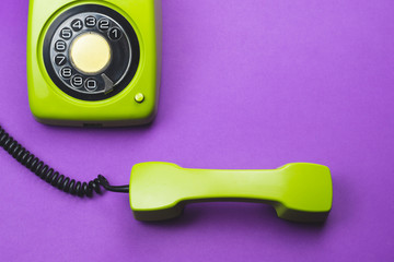 Classic phone with handset. vintage green telephone with phone receiver isolated on purple background. old communication technology