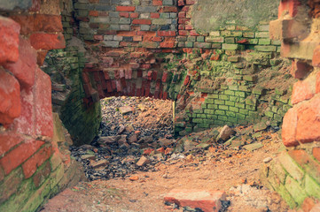 Destroyed overgrown brick wall of ruined building