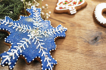 blue gingerbread snowflake on a wooden background. greeting card.