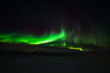 Dramatic polar lights, Aurora borealis with many clouds and stars on the sky over the mountains in the North of Europe - Abisko, Sweden. long shutter speed.