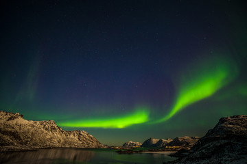 Fototapeta na wymiar aurora borealis, polar lights, over mountains in the North of Europe - Lofoten islands, Norway