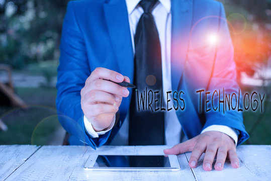 Text sign showing Wireless Technology. Business photo text a technology that allows wireless communication Businessman holds pen and points into copy space