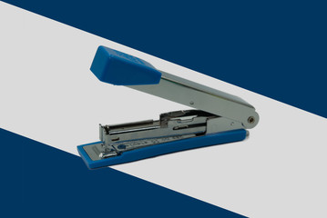 Blue stapler with blue and white background. Office equipment.