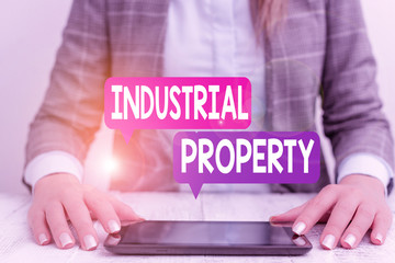 Word writing text Industrial Property. Business photo showcasing the intangible ownership of a trademark or patent Business woman sitting with mobile phone on the table