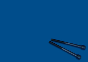 two screw bolts on the classic blue background, long bolts, technic, repair