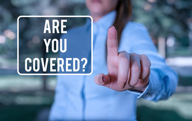 Handwriting text writing Are You Covered Question. Conceptual photo asking showing if they had insurance in work or life Woman in a blue business shirts pointing with her finger into empty space