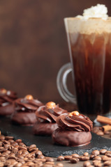  Chocolate dessert with hazelnut and coffee with cream on a wooden table.
