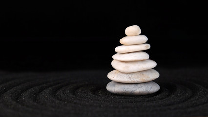 Fototapeta na wymiar zen stones on the dark sand with copy space