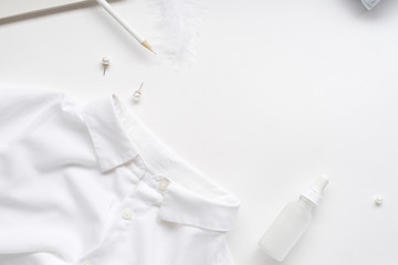White monochromatic flatlay on white background. Clothes, accessories, stationery and beauty...