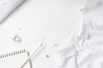 White monochromatic flatlay on white background. Clothes, accessories, stationery and beauty...