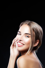 Fototapeta premium Beautiful hapy model woman, teeth smiling, perfect skin, makeup, blonde hair style. Black background. Copy space