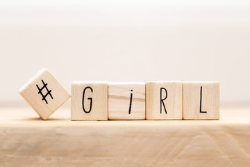 Wooden cubes with a hashtag and the word girl, social media concept