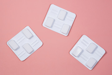 White vaginal antibacterial pills on pink background.Candles are soaked in water and injected into vagina to treat candidiasis, thrush, inflammation. Effective modern drug for treatment of diseases