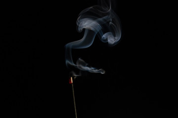 abstract background of smoke from incense stick close up with copy of space on black background. Focus on the smoke