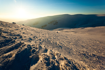 Landscape of mountain valley covered with snow on clear winter frosty day