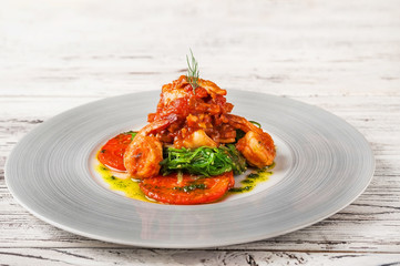 Seafood in a restaurant close-up. Fried seafood in olive oil on a white plate and copy space.