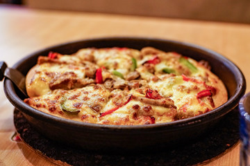 Pizza in a pan on the table close-up. Fast food. Baked chicken pizza for dinner