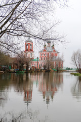 Fototapeta na wymiar Ancient russian church and its reflection in the water surface of the river