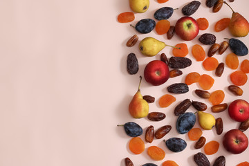 Superfoods on a pink background with a Copyspace. Apples pears plums dates dried apricots