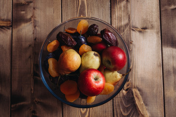 dried apricots and dates plate, plum, apple, pear in a plate, closeup shot