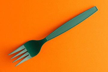 Plastic Fork Isolated On Orange Background, Green Plastic Fork