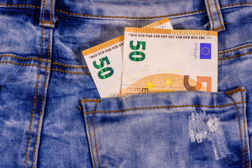 Fifty euro banknotes in pocket of the blue jeans