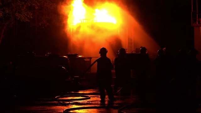 Fireman training Spray water curtain , group of firefighters helped stop the fire. Fire in the Industrial Factory . Rescue ,Education ,Emergency and Teamwork concept .