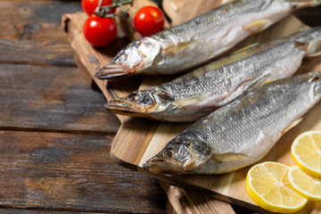 Smoked or dried smelt fish on a wooden Board on a brown wooden table