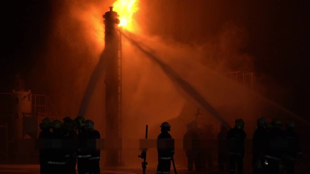 Fireman training Spray water curtain , group of firefighters helped stop the fire. Fire in the Industrial Factory . Rescue ,Education ,Emergency and Teamwork concept .
