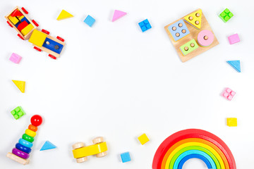 Baby kids toys background. Wooden educational geometric stacking blocks toy, wooden train, car, rainbow, airplane and colorful blocks on white background. Top view, flat lay