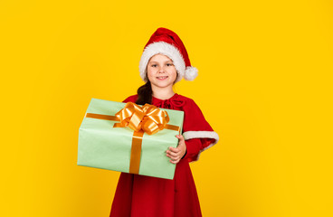 Time to celebrate. smiling child in santa hat. let your xmas be bright. childhood happiness. little elf hold gift box. new year preparation. christmas shopping time. toy shop and gifts for children