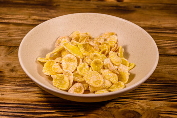 Ceramic plate with cornflakes on a wooden table. Healthy eating