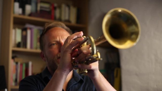 Hombre de mediana edad de pelo rubio tocando la trompeta