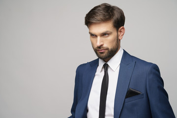 studio photo of young handsome businessman wearing suit