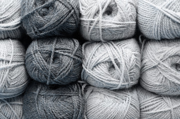 background of rows skeins of fluffy wool yarn for knitting different cold gray colors