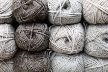 background of rows skeins of fluffy wool yarn for knitting different warm gray colors