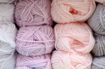 background of rows skeins of fluffy wool yarn for knitting different pastel colors