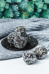 rum chocolate balls with coconut flakes on tray. Sweet raw vegan balls. Chocolate, coconut, dates and banana. Wooden background. Healthy lifestyle. 