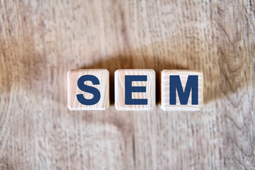 Text - SEM on wooden cubes, on wooden background